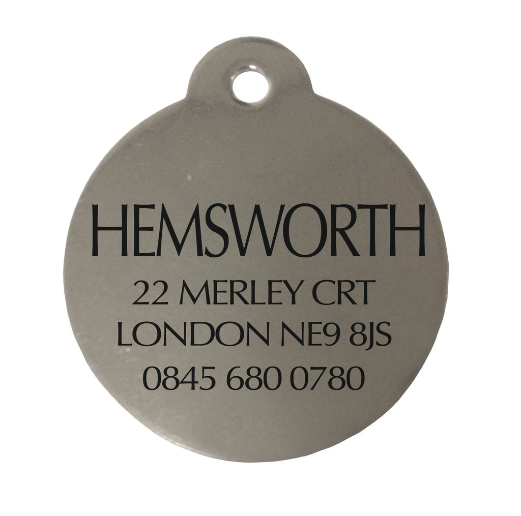 Round metal tag with engraved text on a white background